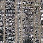 Vista aérea de um amplo estacionamento repleto de veículos novos no Brasil