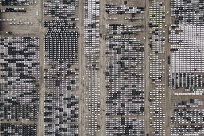 Vista aérea de um amplo estacionamento repleto de veículos novos no Brasil
